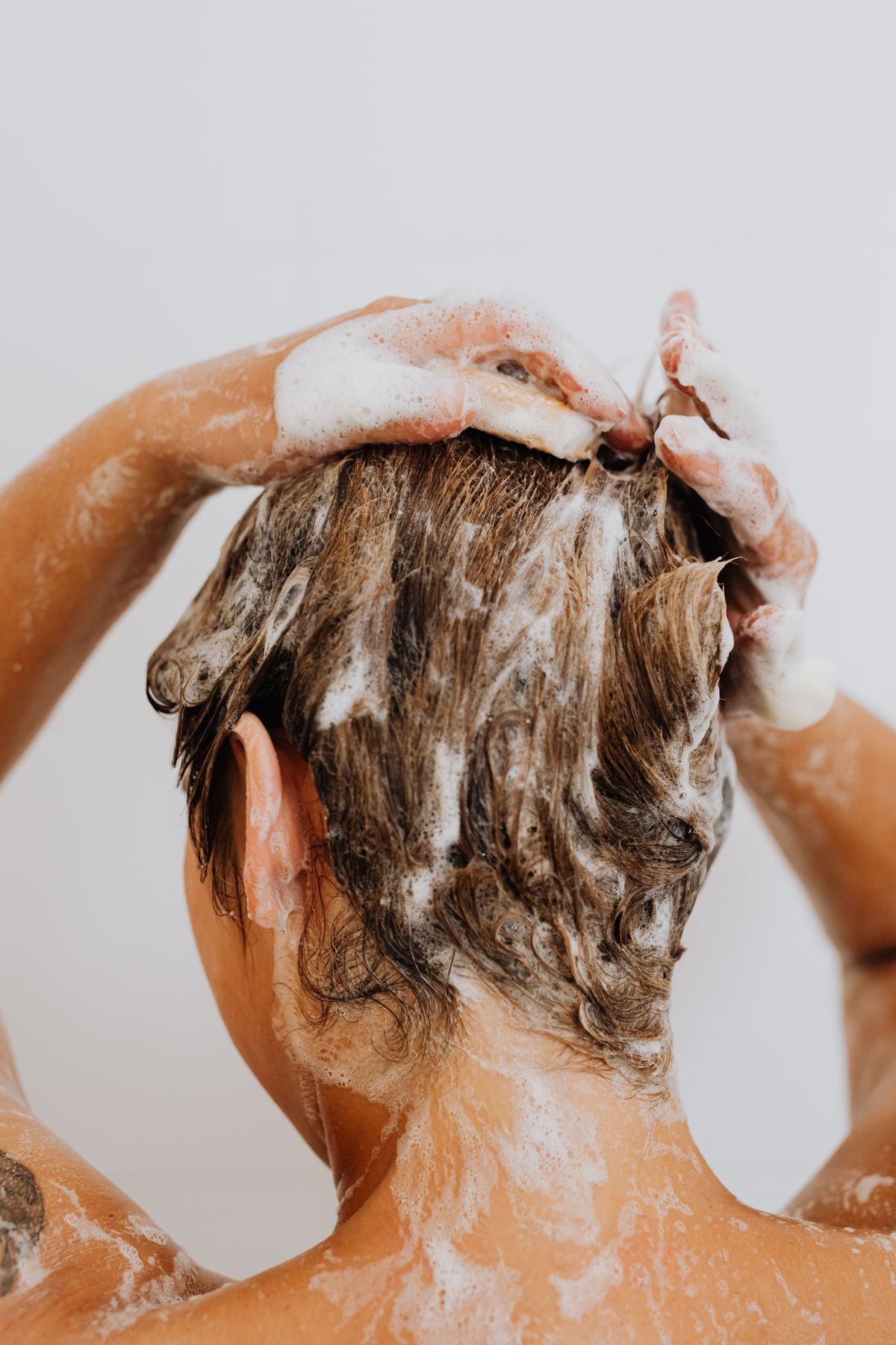 Lavado del cabello con champú en la ducha