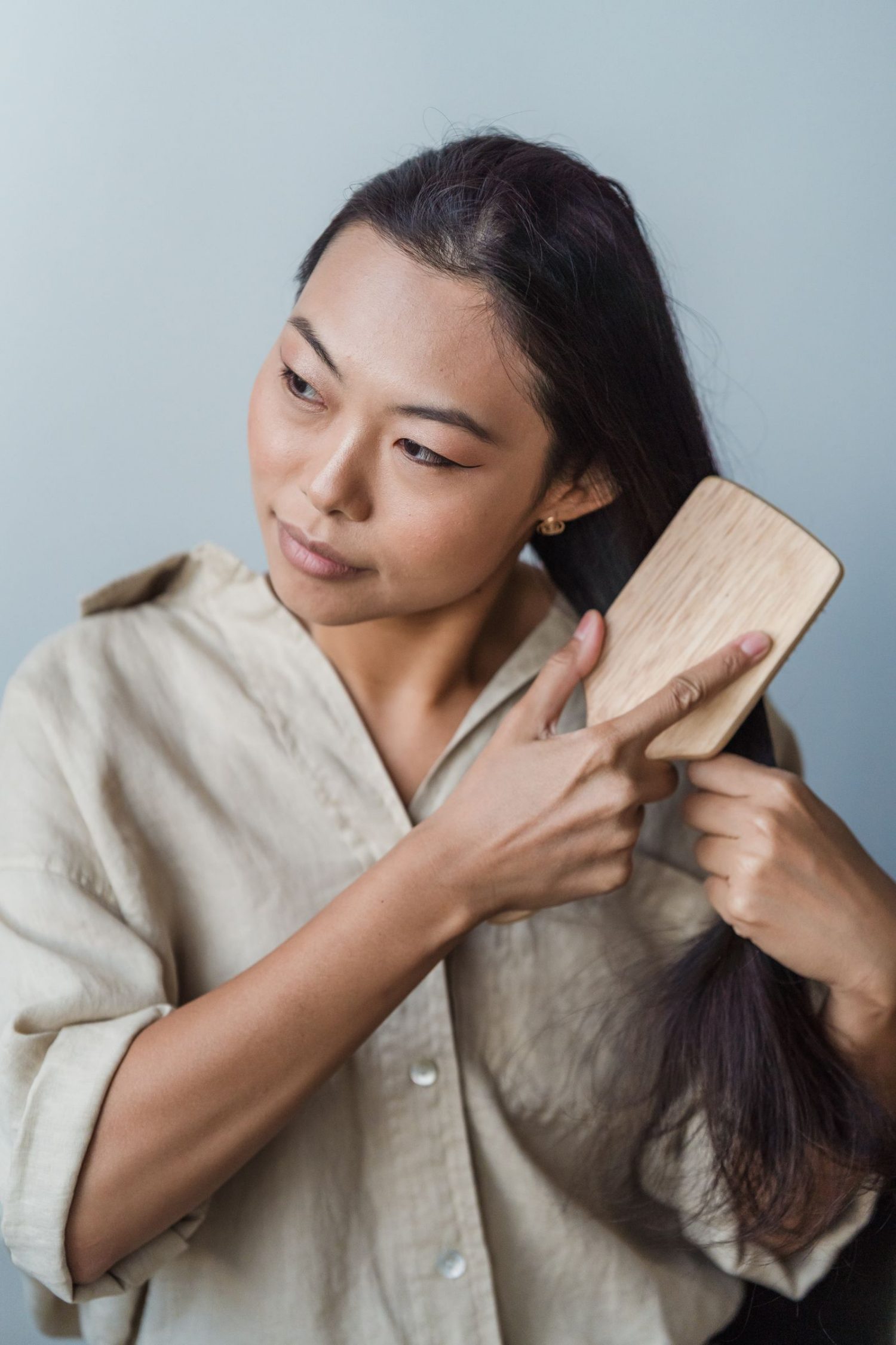 Mujer cepillándose el cabello con un cepillo de madera