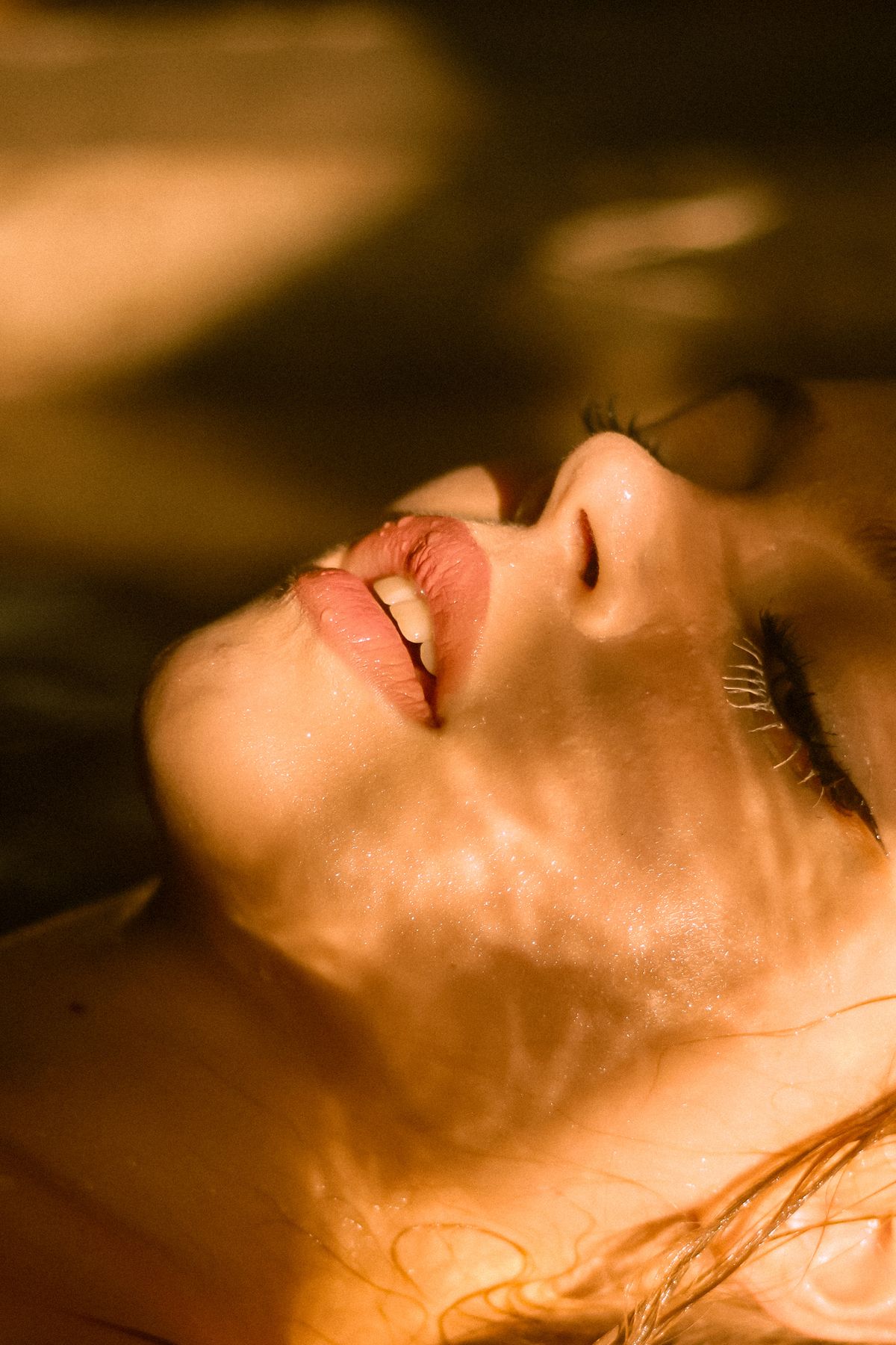 Primer plano del rostro de una mujer con la luz del sol proyectando sombras sobre la piel
